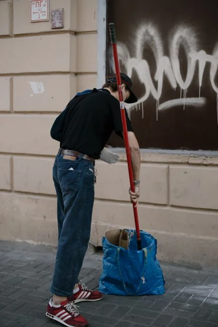 A man cleaning skyscraper windows with a harness, showcasing urban high-rise work.